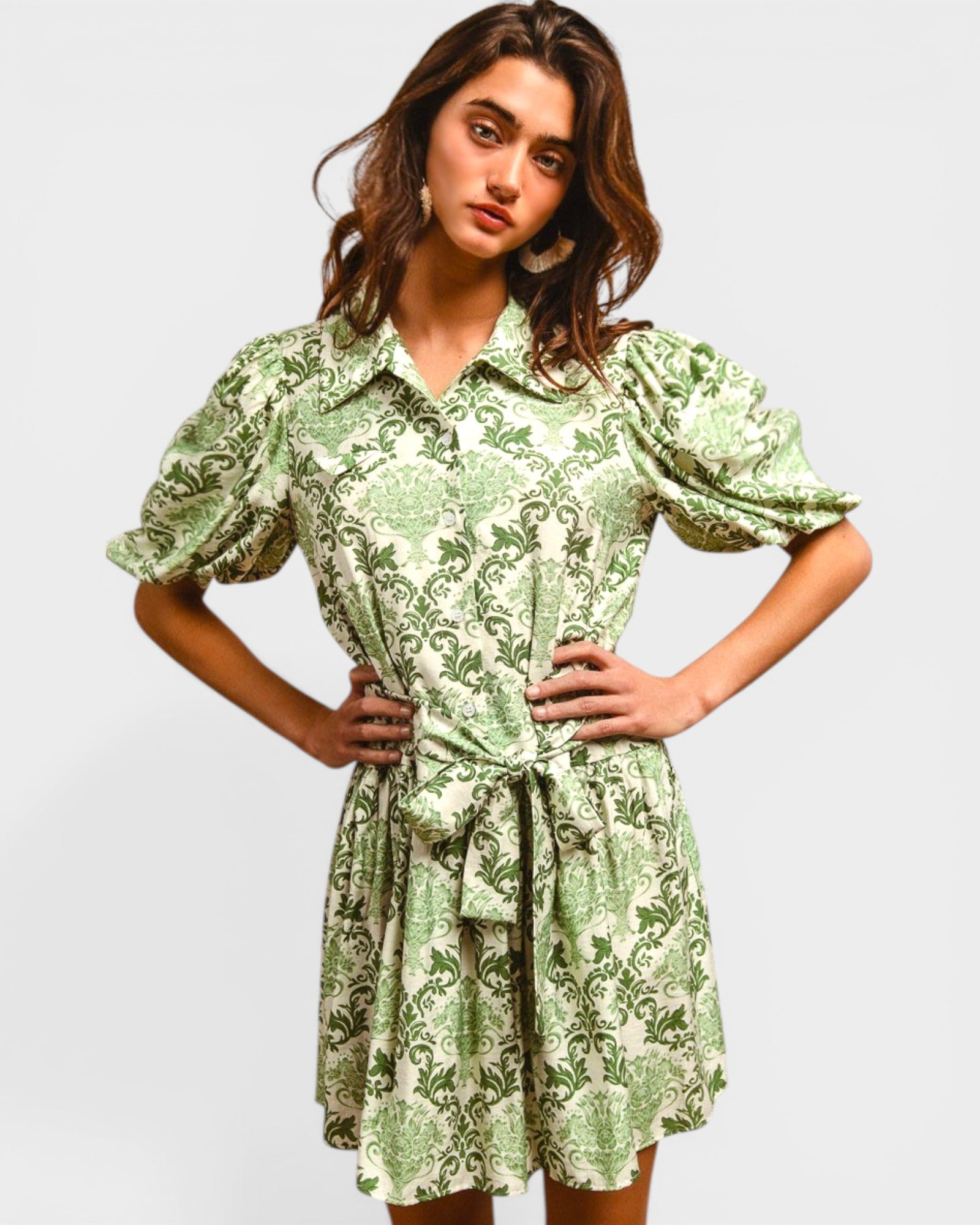 Woman wearing a green floral dress against a plain background