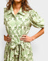 Green patterned dress worn by a person on a light gray background