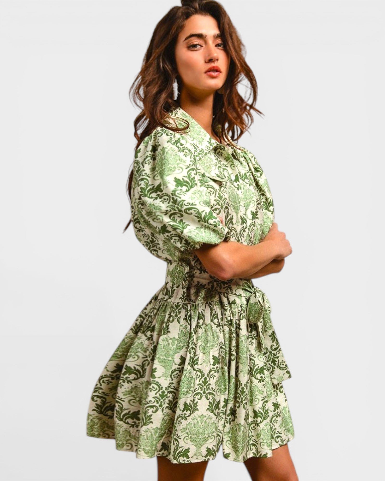 Woman wearing a green floral dress against a plain background