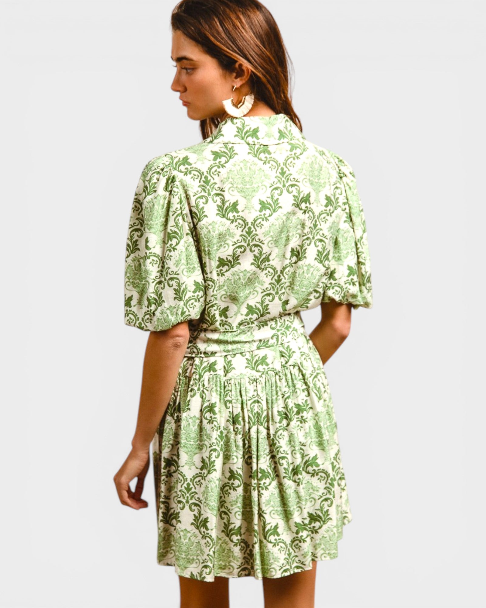 Woman wearing a green floral dress on a white background
