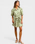 Woman wearing a green floral dress on a white background