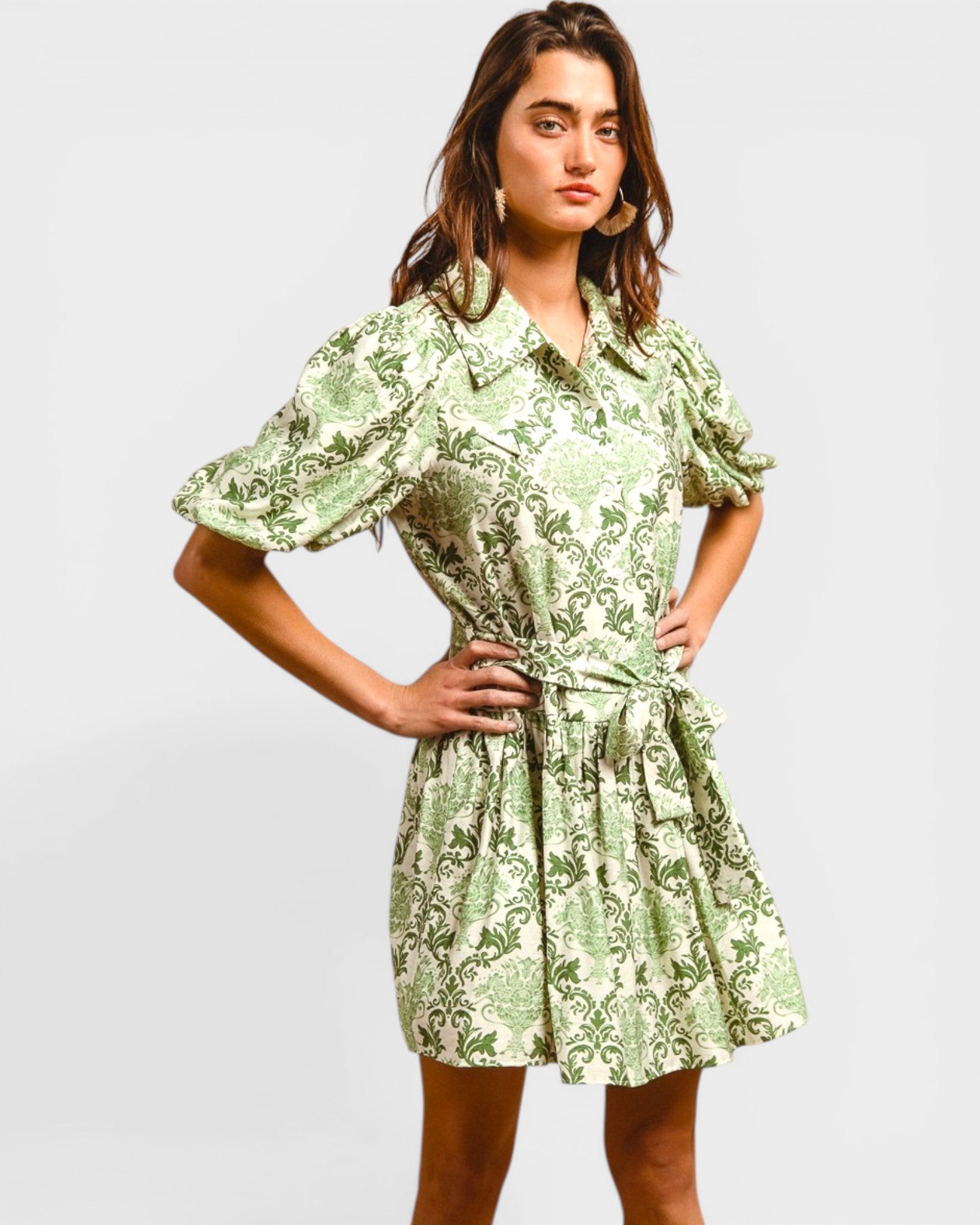Woman wearing a green floral dress against a plain background