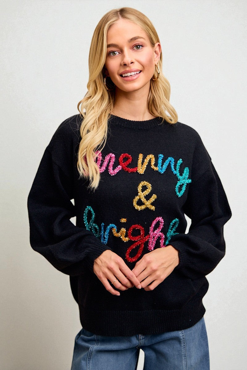 Person wearing a black sweater with colorful text on a plain background