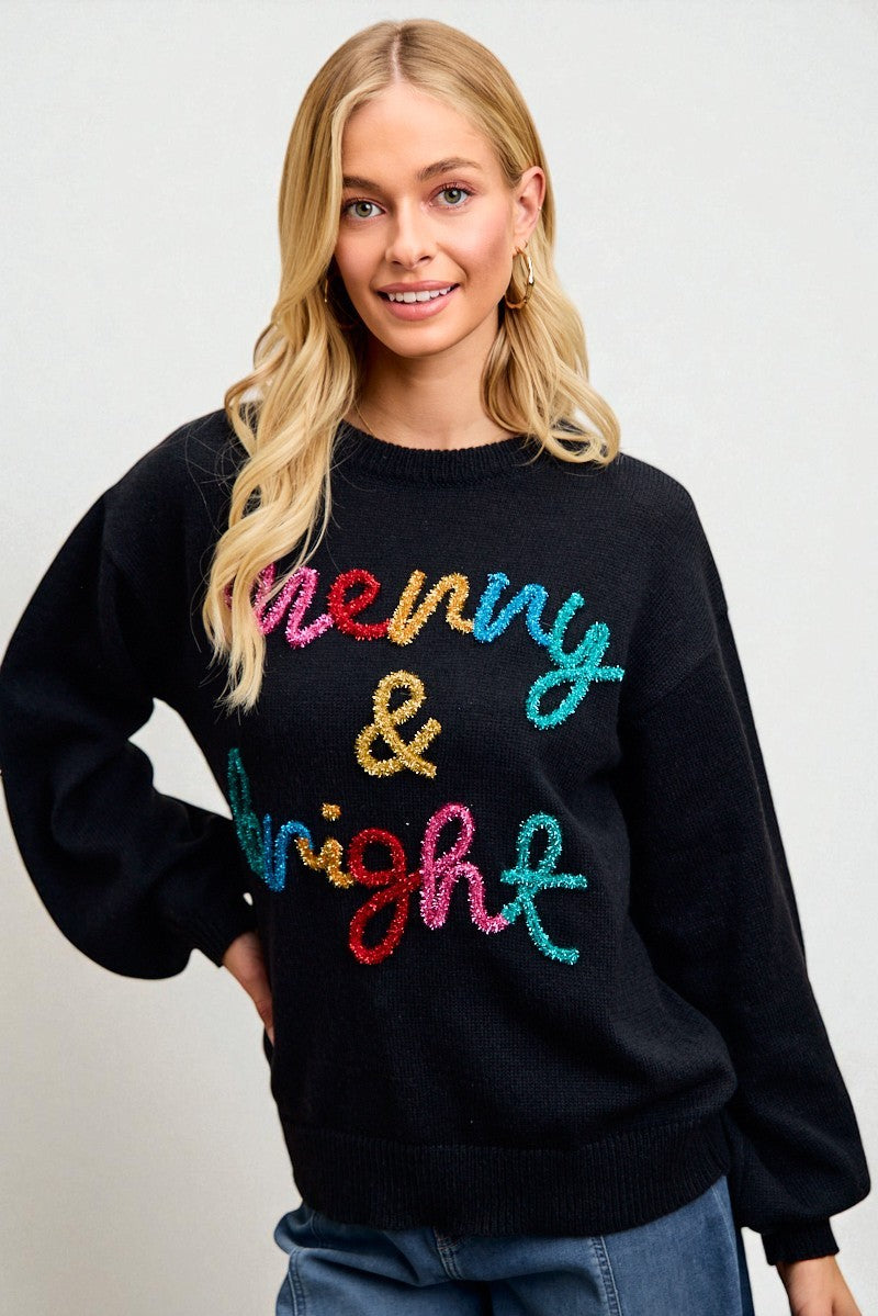 Woman wearing a black sweater with colorful text on a plain background