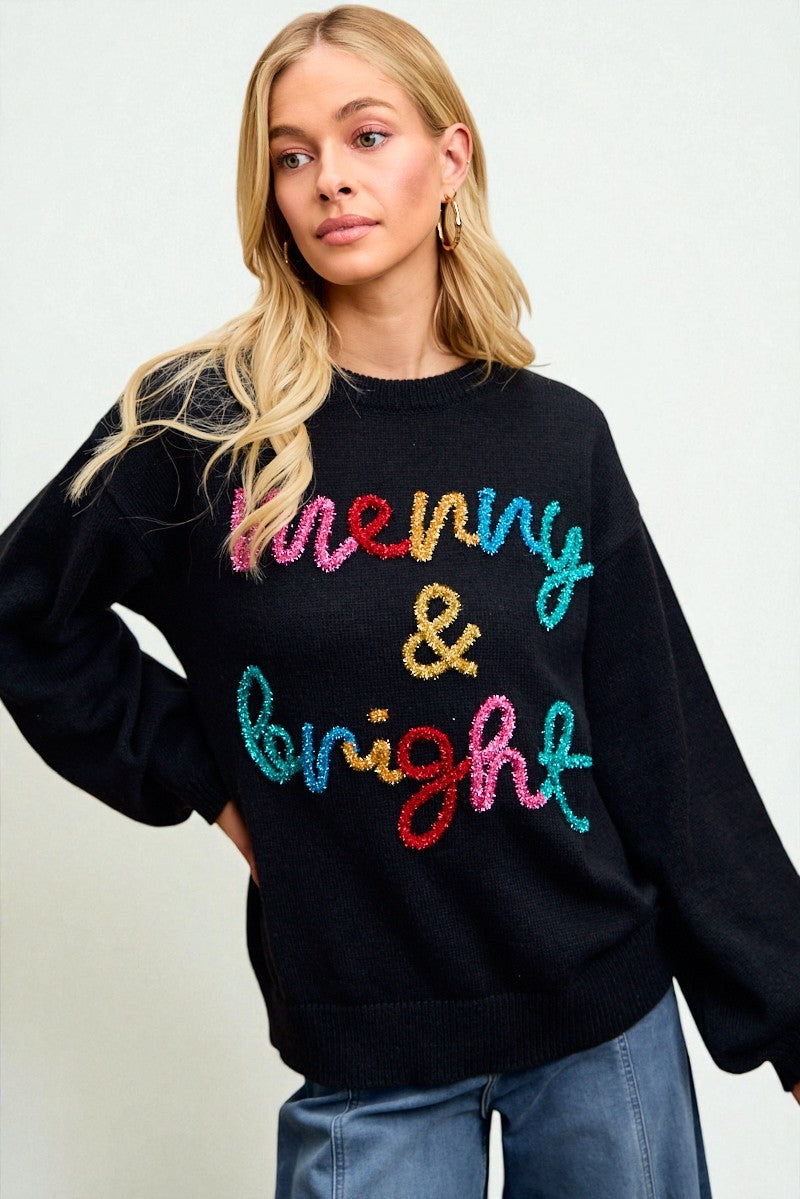 Woman wearing a black sweater with colorful text on a plain background