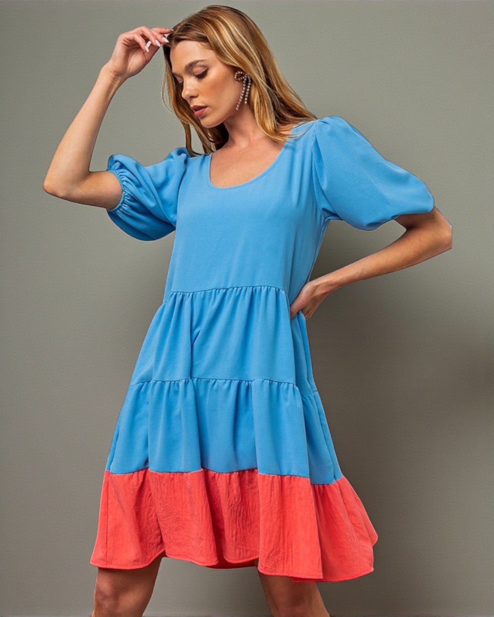 Woman wearing a blue and red dress against a gray background