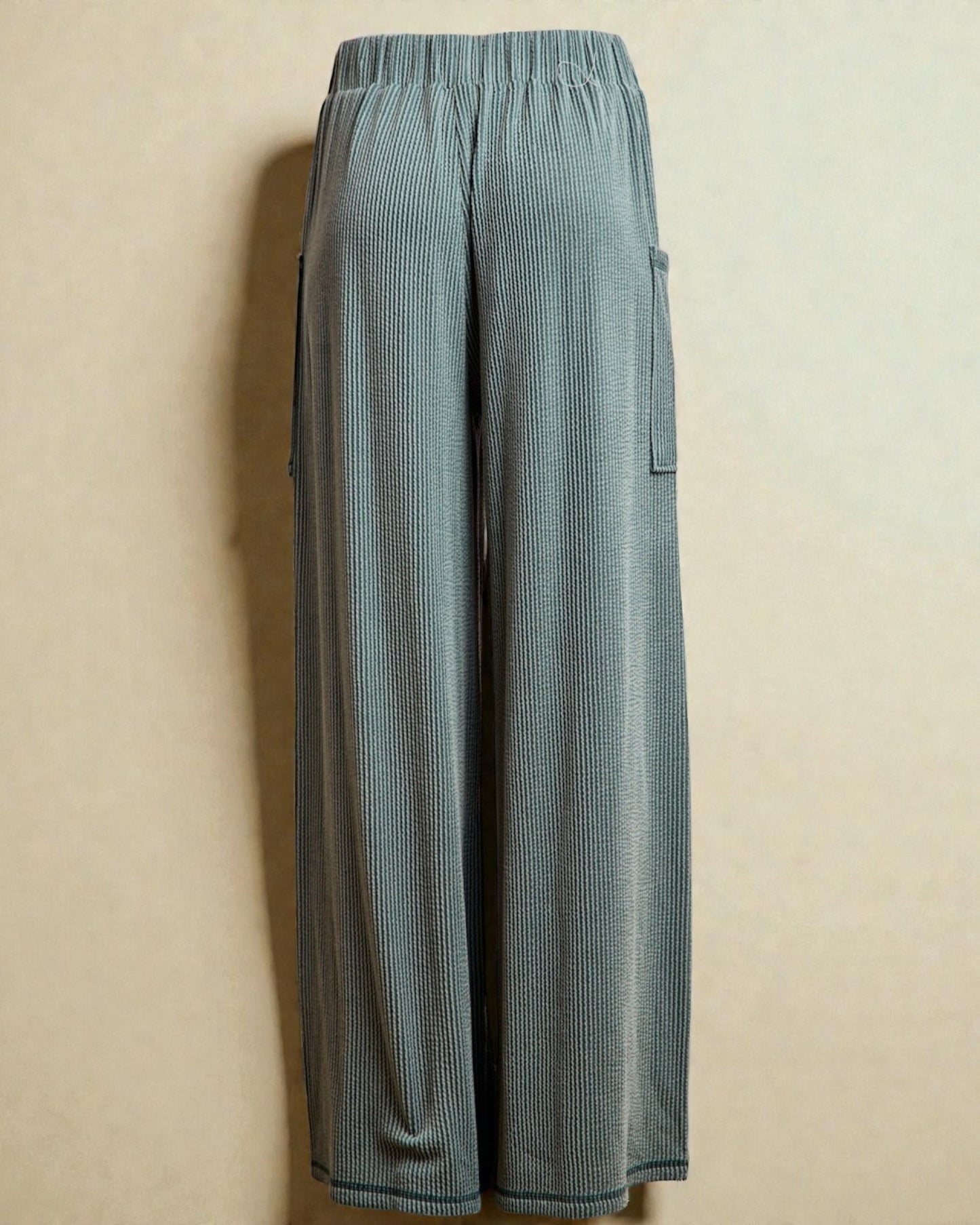 Light blue ribbed pants on a beige background