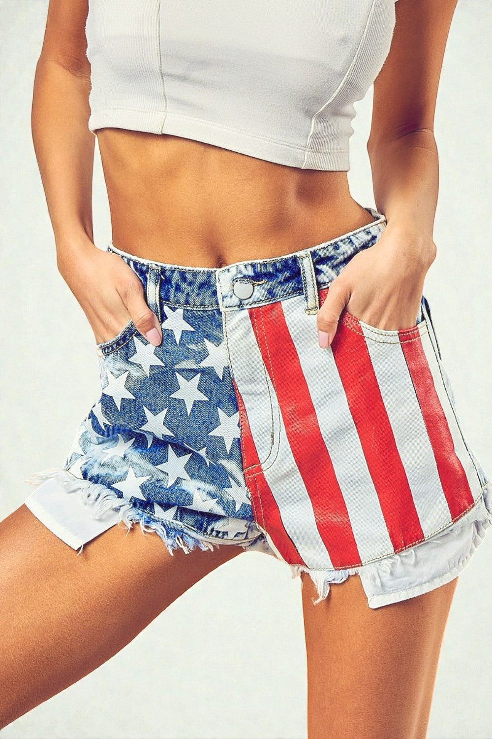 Person wearing denim shorts with American flag pattern on a plain background
