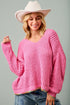 Woman wearing a pink sweater and cowboy hat against a gray background