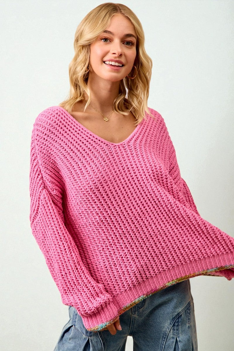 Woman wearing a pink sweater against a white background