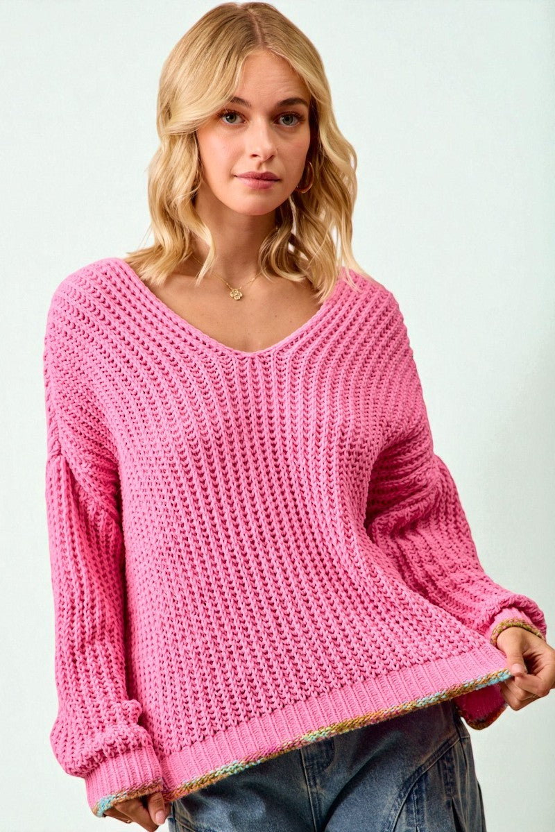 Woman wearing a pink knitted sweater on a white background
