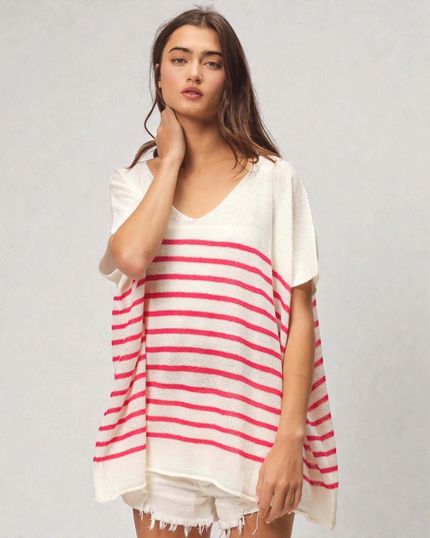 Woman wearing a white and red striped cover-up on a plain background