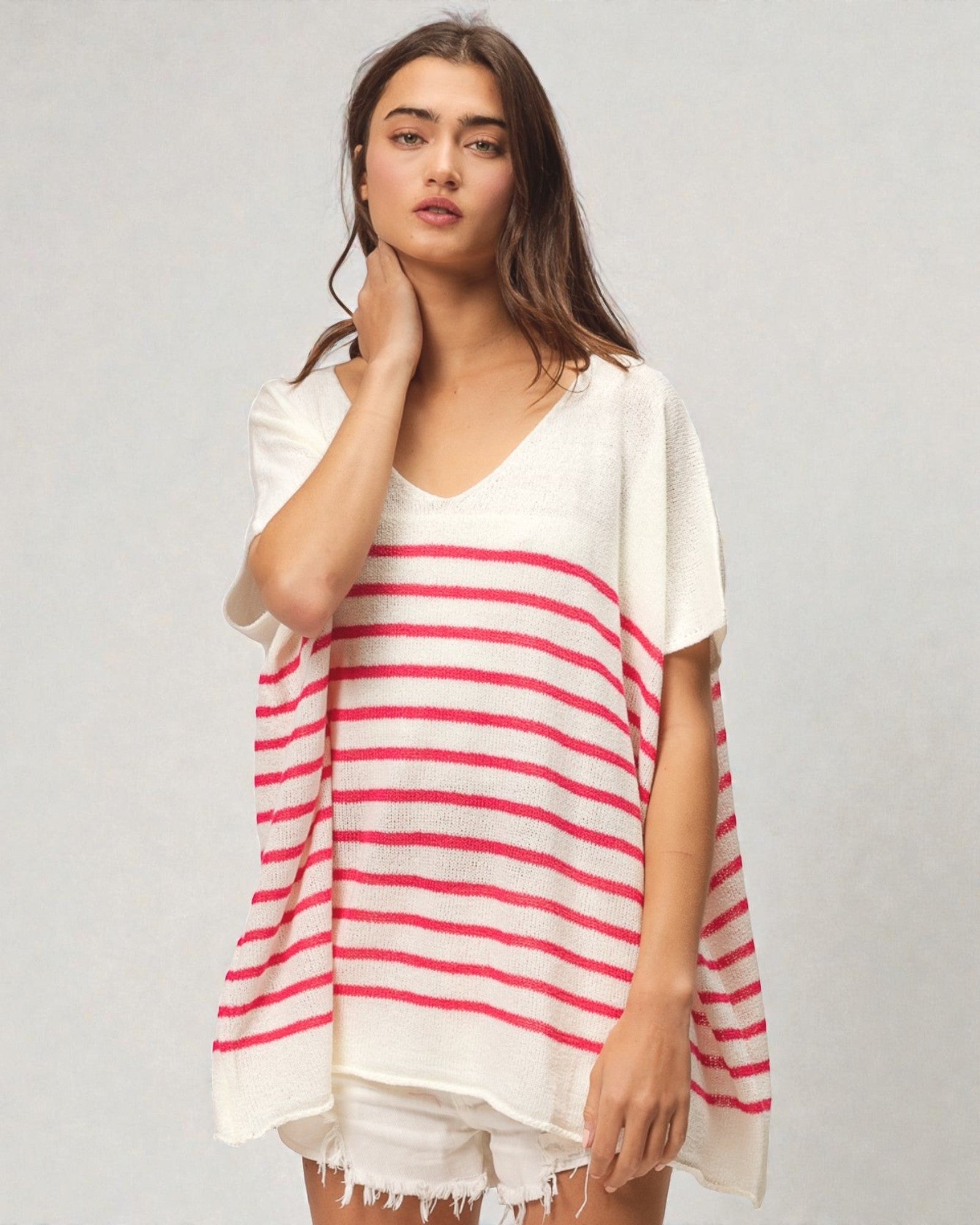 Woman wearing a white and red striped cover-up on a plain background