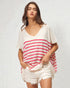 Woman wearing a white and red striped top with white shorts on a plain background