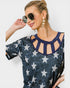 Woman wearing a navy blue top with star pattern and sunglasses on a white background