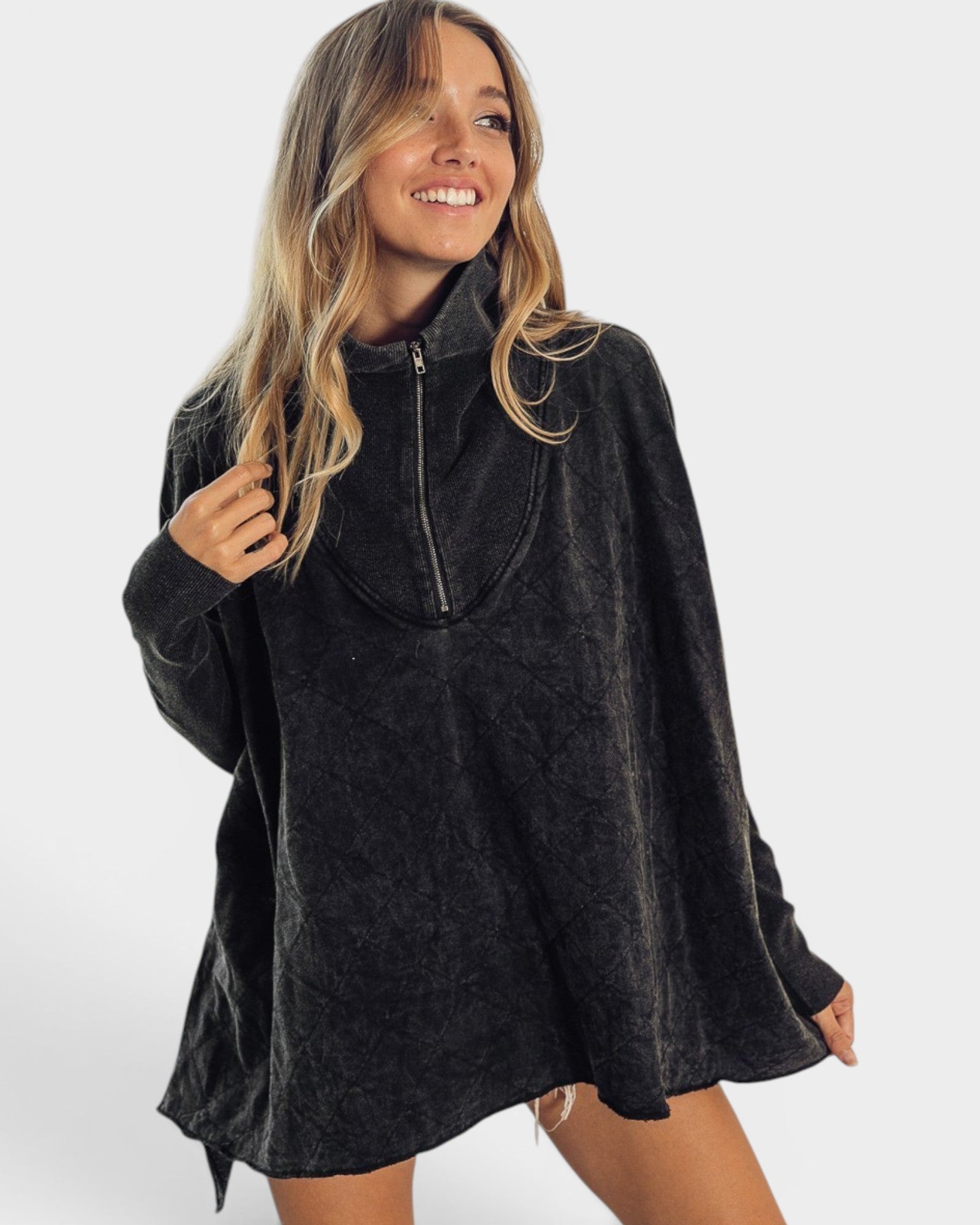 Woman wearing a dark gray poncho on a white background