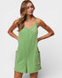 Woman wearing a green dress with pockets on a plain background