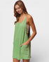 Woman wearing a green sleeveless dress with a pocket on a white background