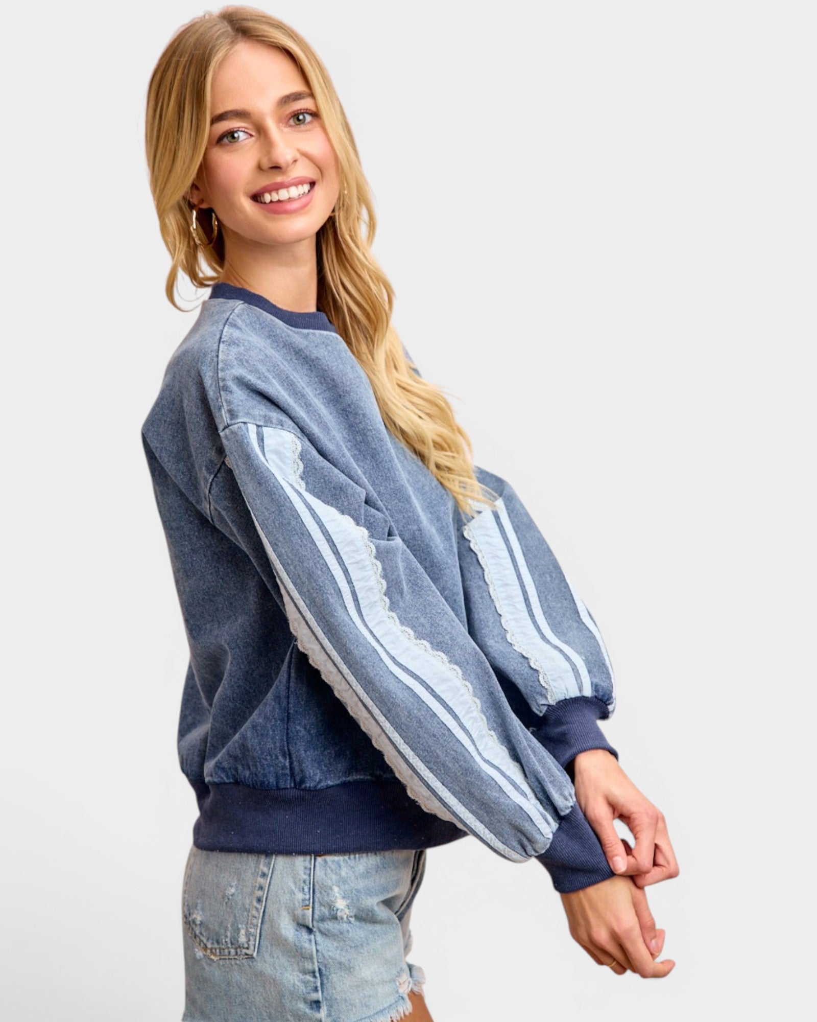 Woman wearing a blue and white striped sweatshirt on a plain background