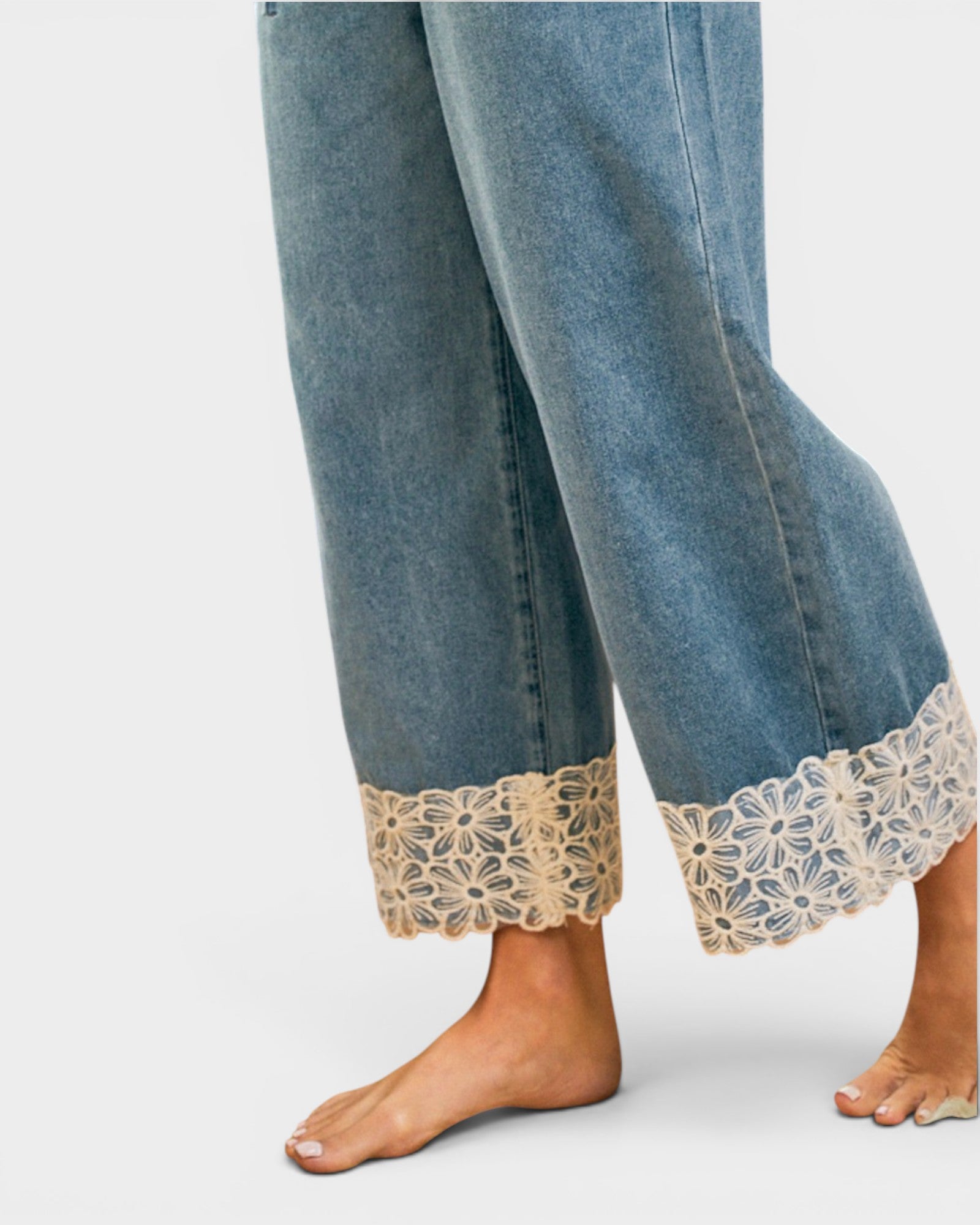 Denim pants with lace cuffs on a white background