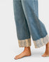 Denim pants with lace cuffs on a white background