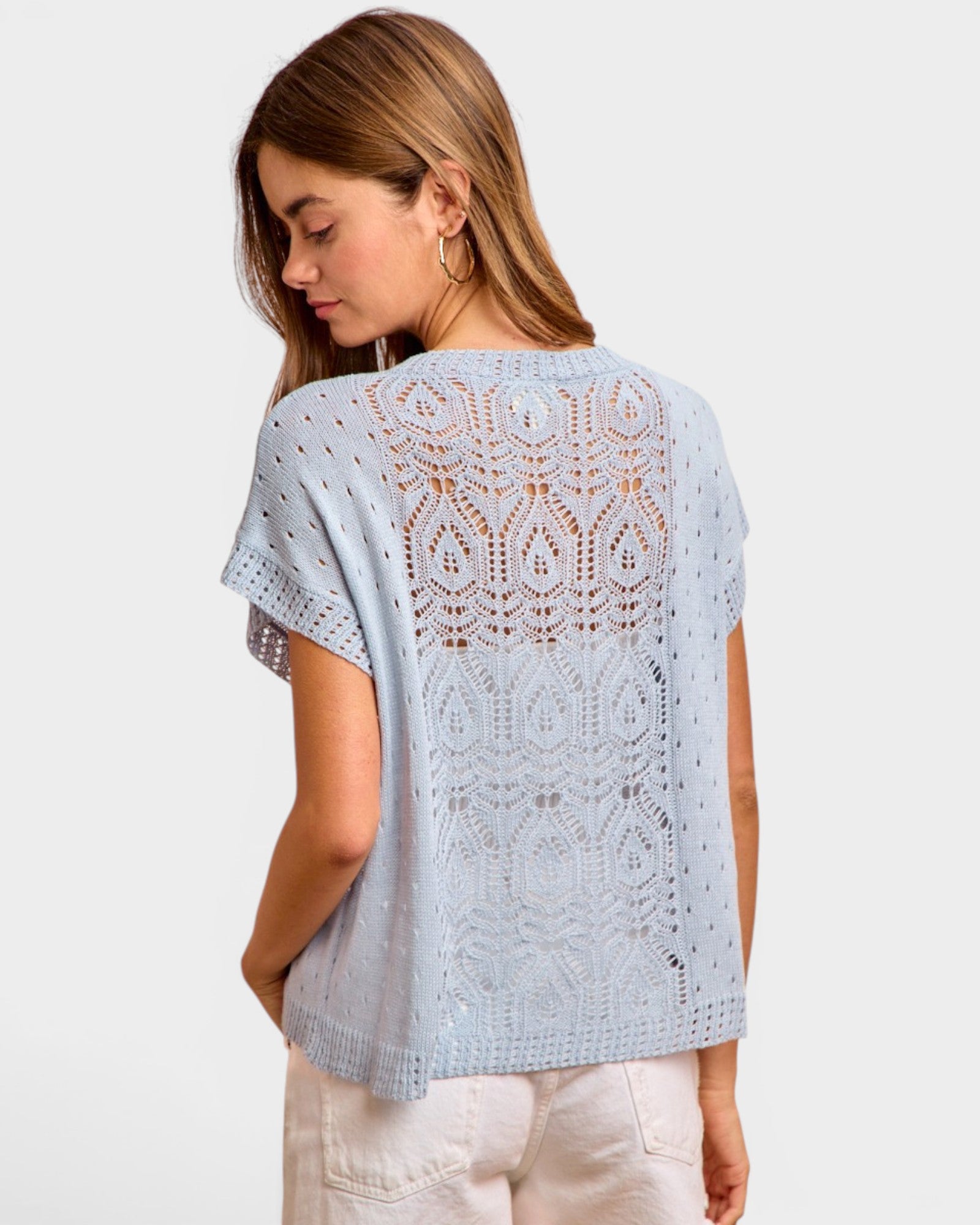 Woman wearing a light blue lace top on a white background