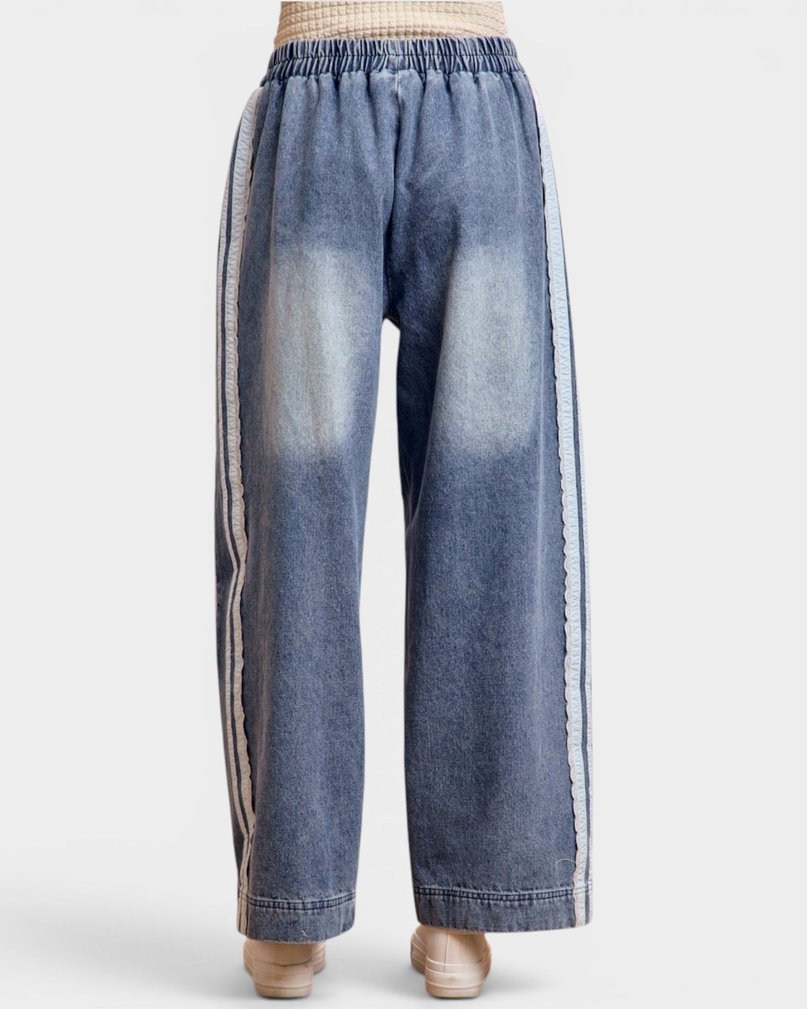 Blue denim pants with side stripes on a white background