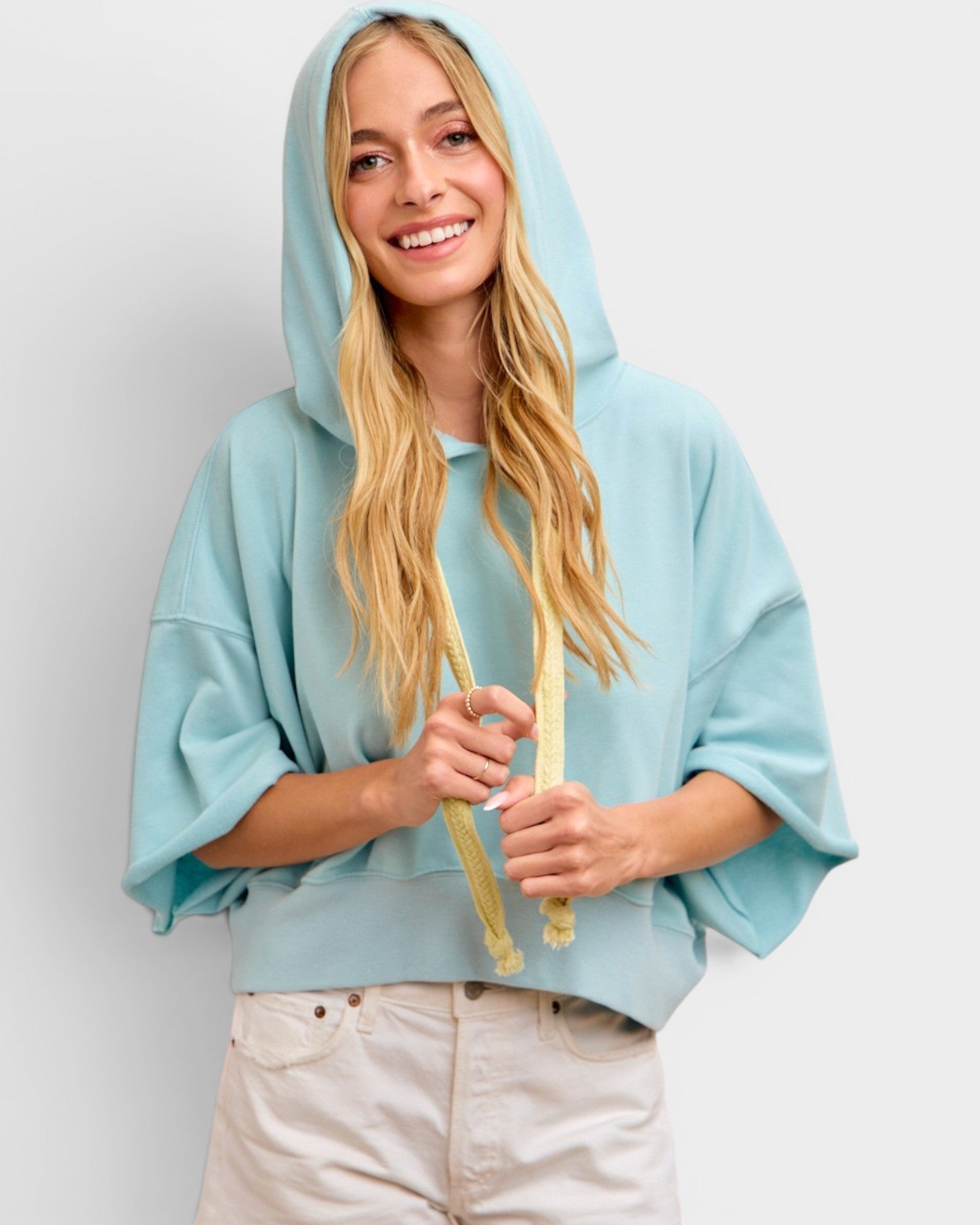 Woman wearing a light blue hoodie against a plain background