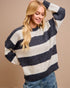 Woman wearing a navy and white striped sweater against a beige background