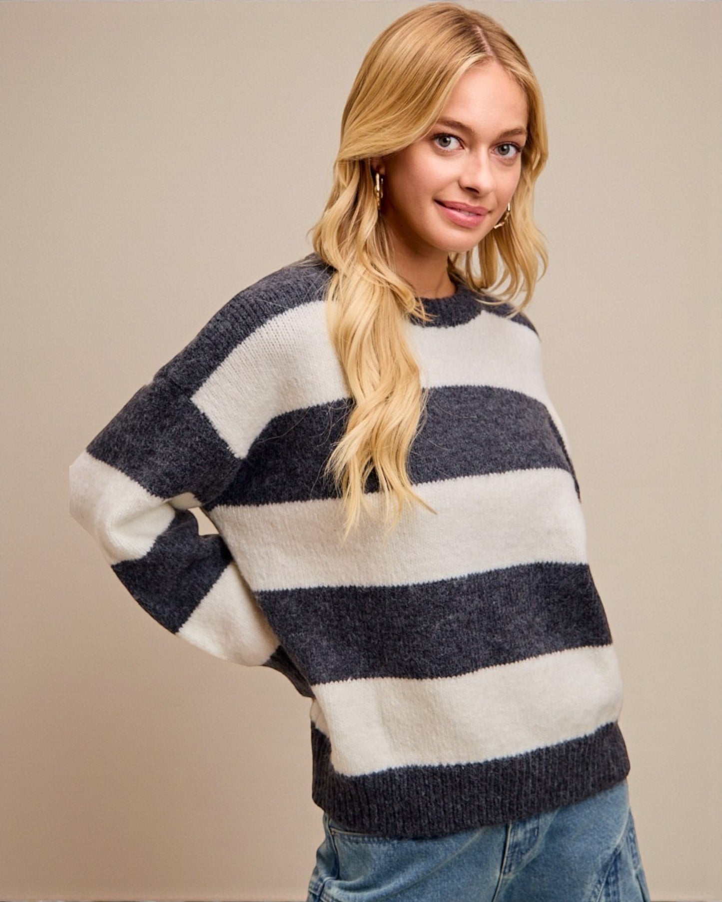 Woman wearing a striped sweater against a beige background