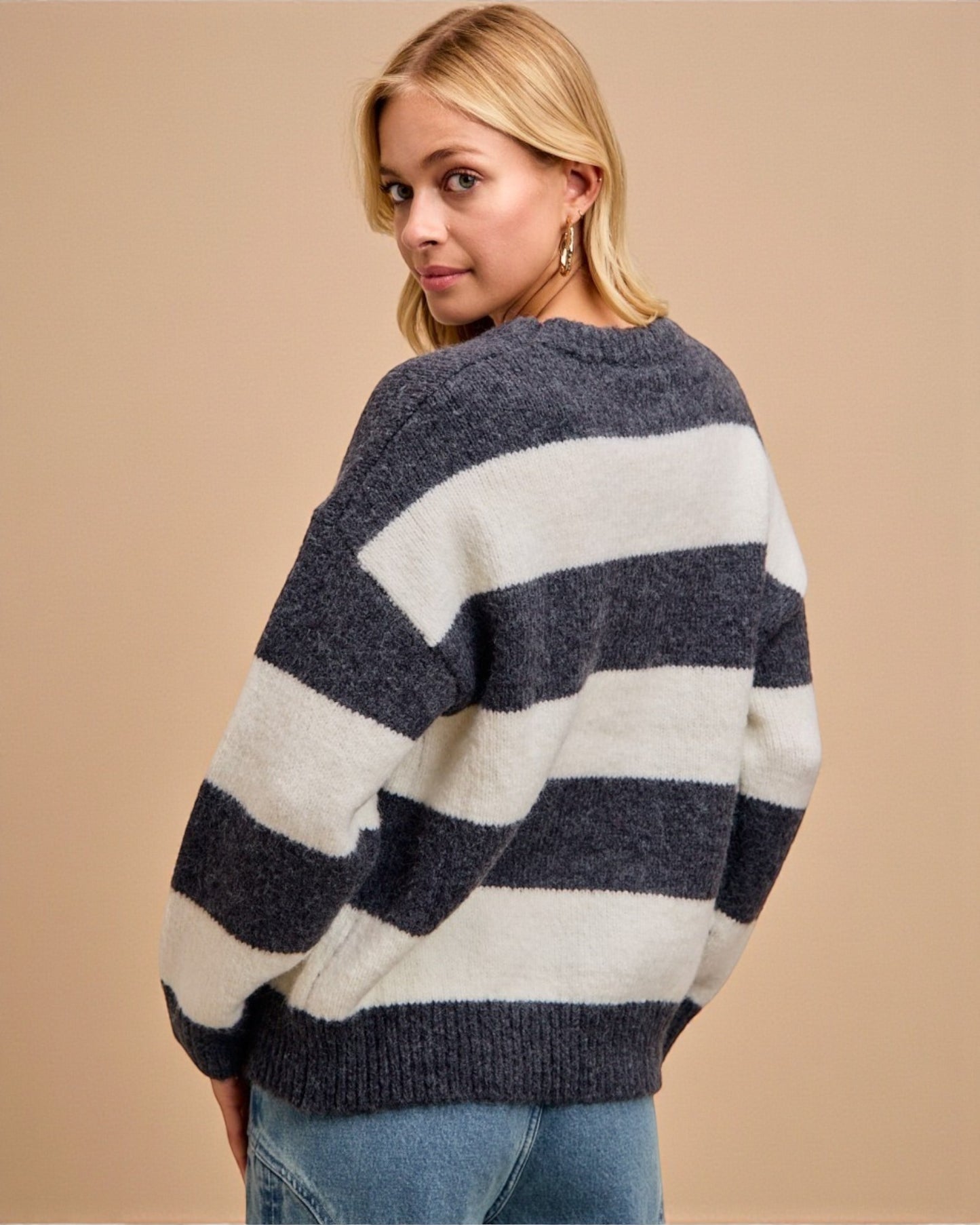 Woman wearing a striped sweater against a beige background