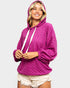 Woman wearing a pink hoodie on a plain background