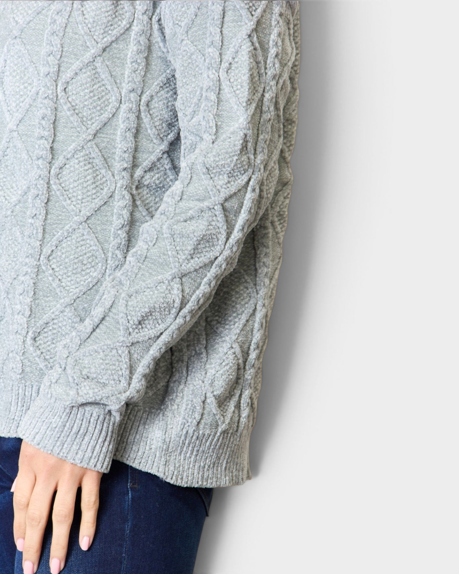 Gray cable knit sweater on a white background