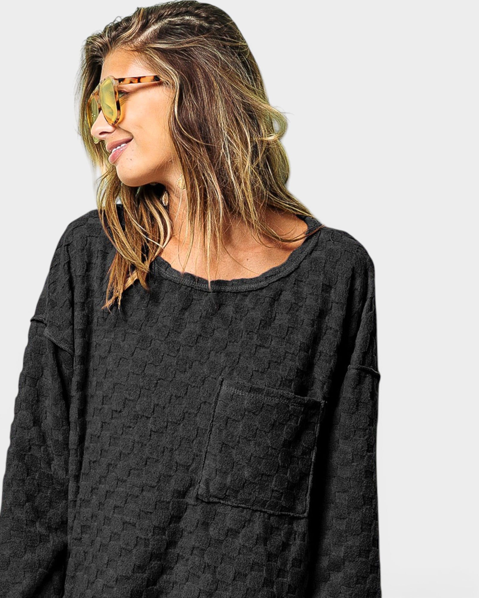 Woman wearing a dark gray textured shirt against a plain background