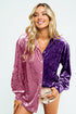 Woman wearing a two-tone velvet shirt with pink and purple sections on a white background