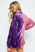 Woman wearing a two-tone purple and pink velvet jacket on a white background
