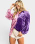Woman wearing a two-tone pink and purple velvet shirt on a white background