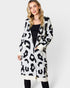 Woman wearing a long leopard print cardigan on a white background
