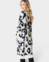 Woman wearing a long, patterned cardigan on a white background