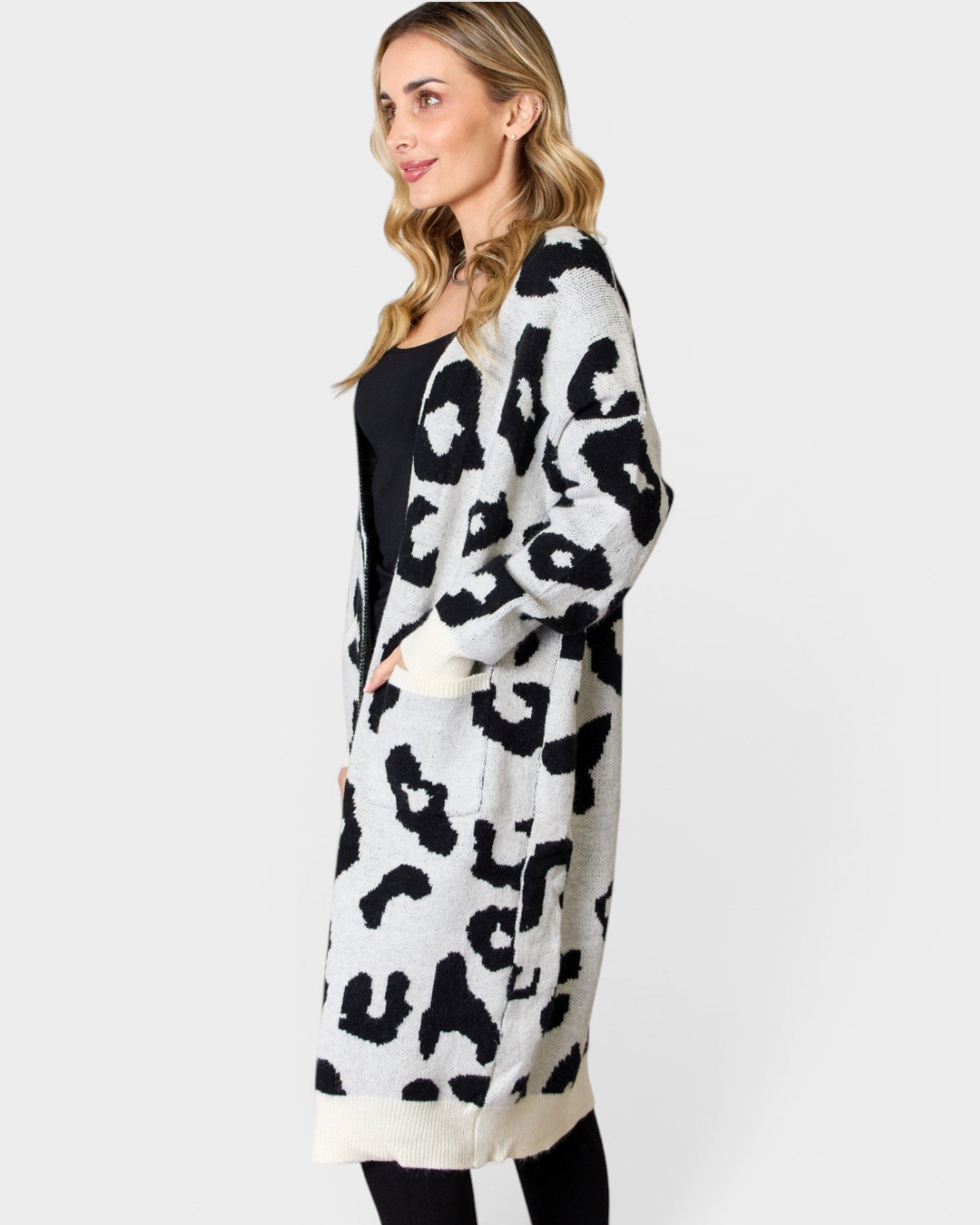 Woman wearing a long leopard print cardigan on a white background