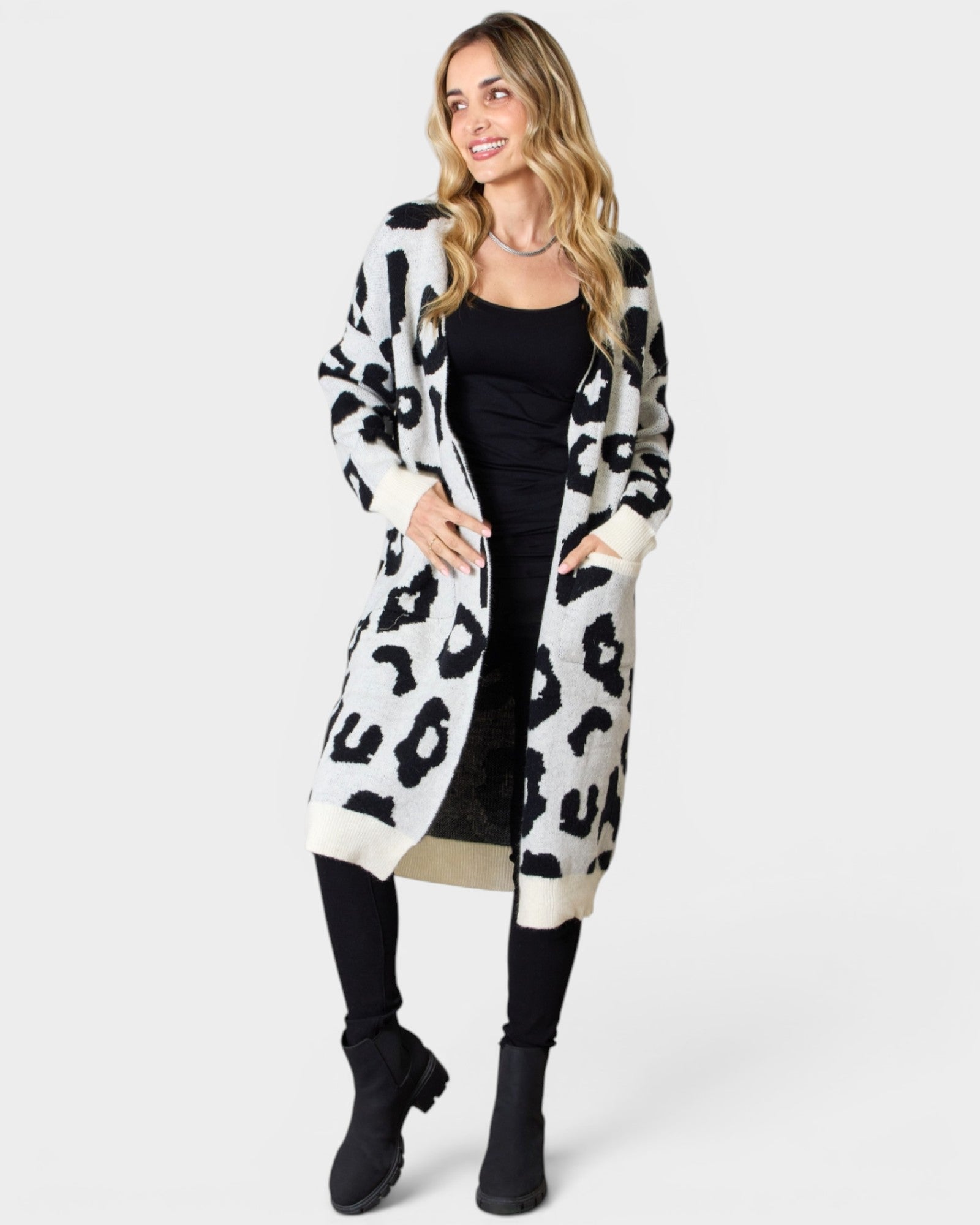 Woman wearing a long, patterned coat on a white background