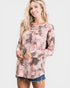 Woman wearing a floral long-sleeve top with cut-out details on a white background