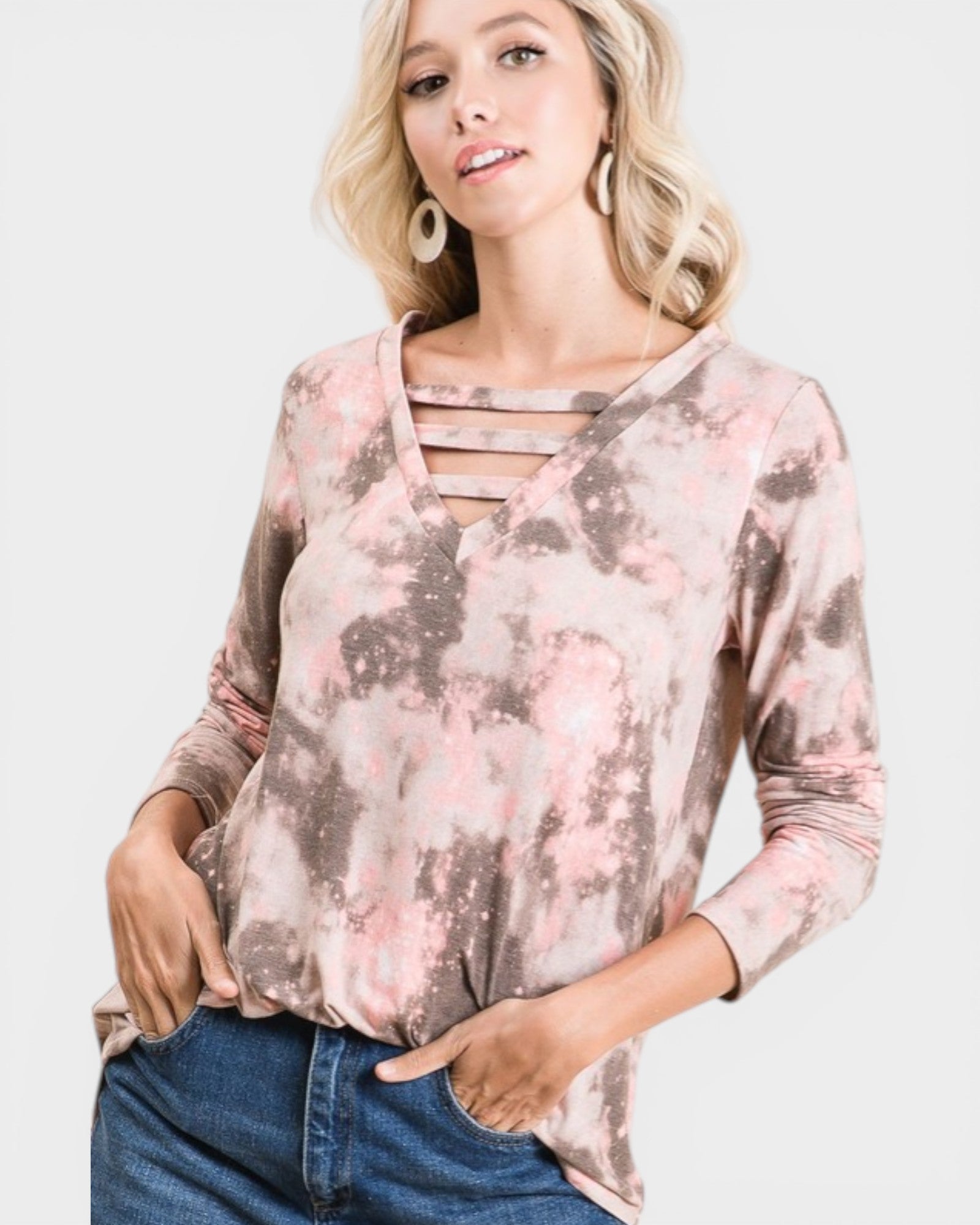 Woman wearing a long-sleeve, floral-patterned top with cut-out details on a white background