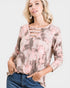 Woman wearing a long-sleeve, floral-patterned top with cut-out details on a white background