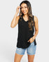 Woman wearing a black sleeveless top and denim shorts on a white background