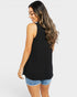 Woman wearing a black sleeveless top and denim shorts on a white background