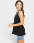 Woman wearing a black sleeveless top and denim shorts on a white background