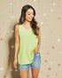 Woman wearing a light green sleeveless top and denim shorts against a beige background with decorative stars.