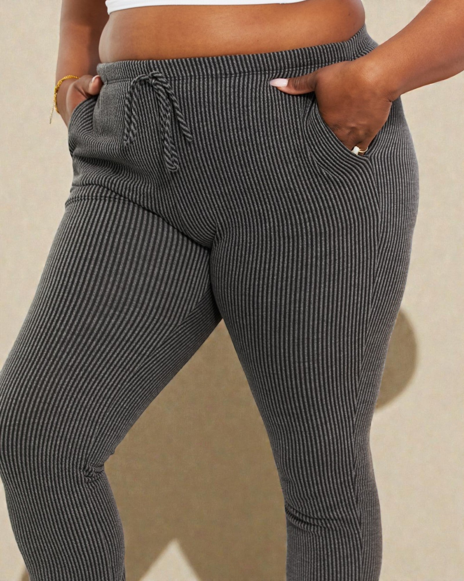 Gray ribbed jogger pants worn by a person on a beige background