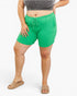 A model wearing bright green ribbed drawstring shorts, a gray ribbed crop top, and tan slide sandals, shown from the waist down against a plain white studio background.